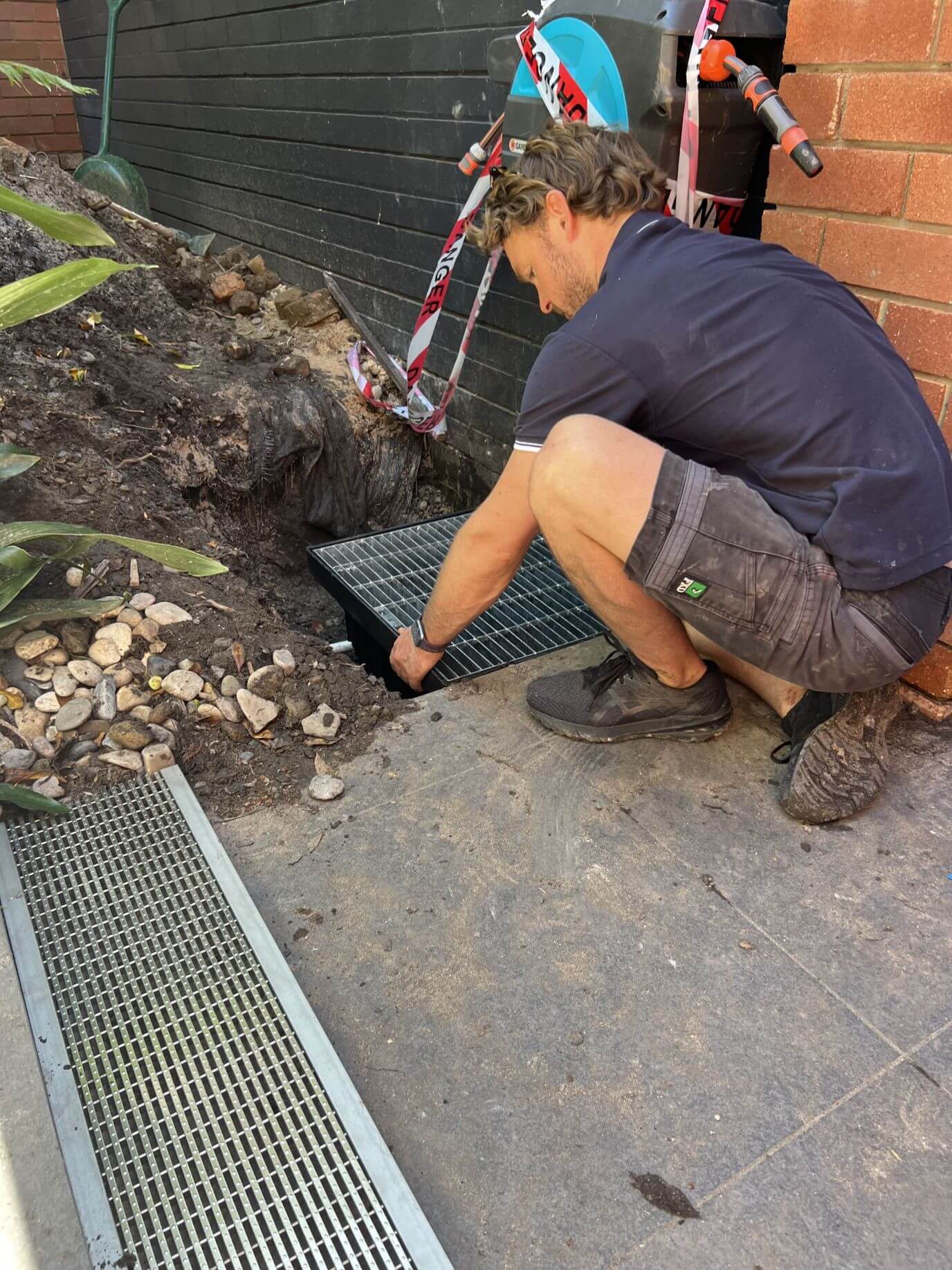 Luke from Safeguard Plumbing installing a new drain cover in Cowan after clearing a blocked drain.