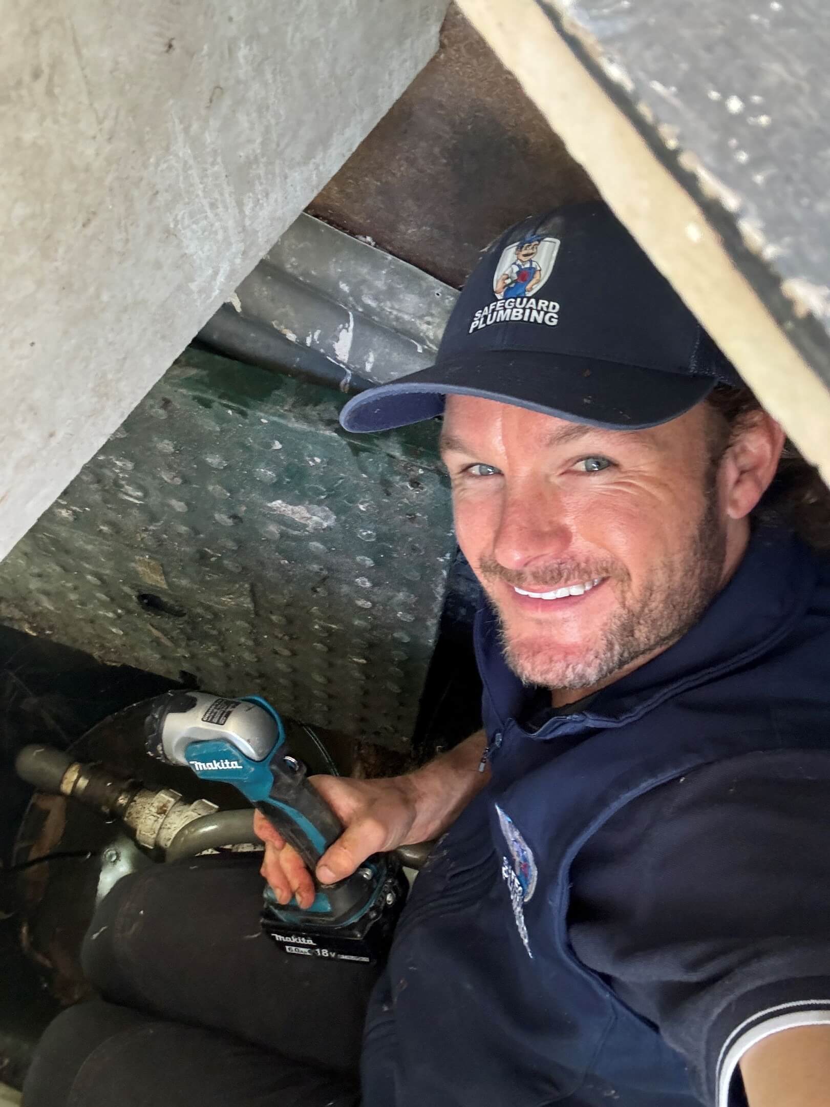 Luke working to clear a drain blockage in Cowan